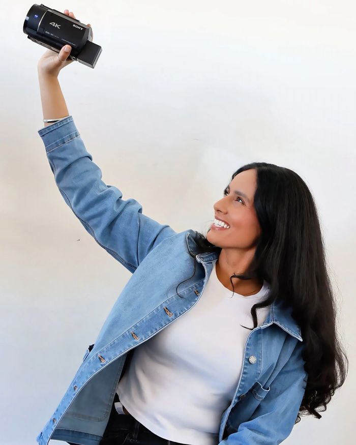 Hanna laughing as she holds the camcorder up high